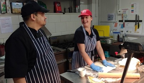 Two cafe staff members preparing dough for corned beef pies