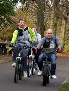 A group of men ride bicycles through a park