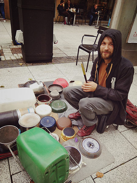 Artist sits with utensils on which he drums to create music