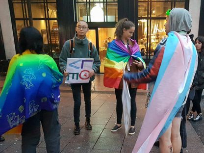 Protesters wearing the LGBT Rainbow Flag and transgender Pride Flag
