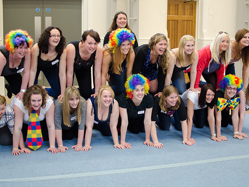 girls in colourful wigs make a human pyramid