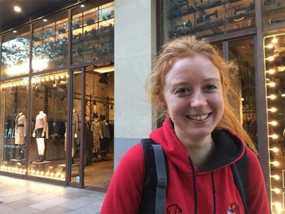 young woman red hiar red jumper in city centre