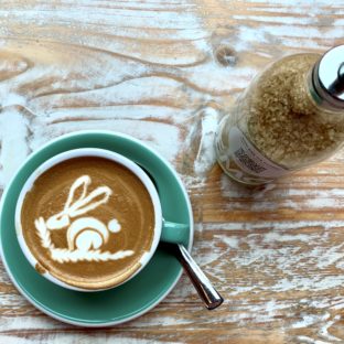 Flat white with a bunny pattern and brown sugar