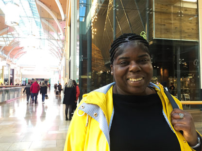 woman wearing a yellow raincoat in shopping centre