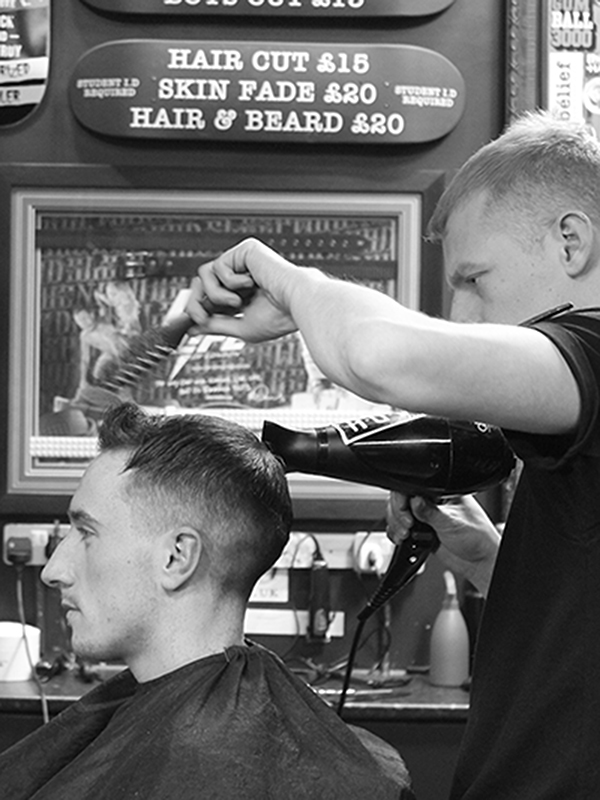 A man having his hair cut at Sleep When You're Dead barbers in Cardiff