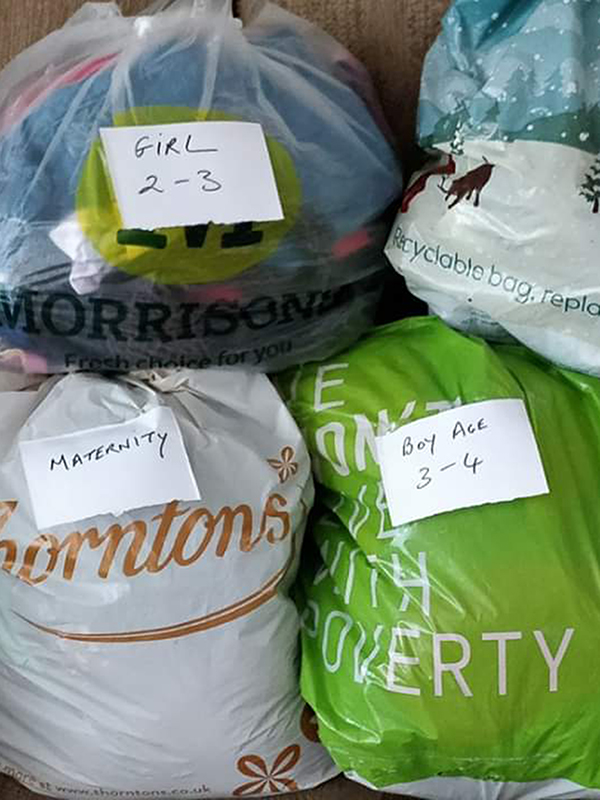 A photo of bags of donated clothing for pregnant asylum seekers and their children