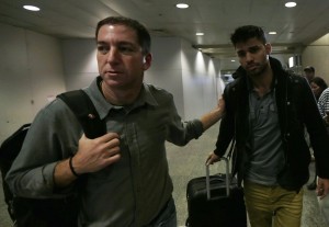U.S. journalist Greenwald walks with his partner Miranda in Rio de Janeiro's International Airport