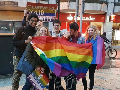 Protesters sharing the rainbow flag