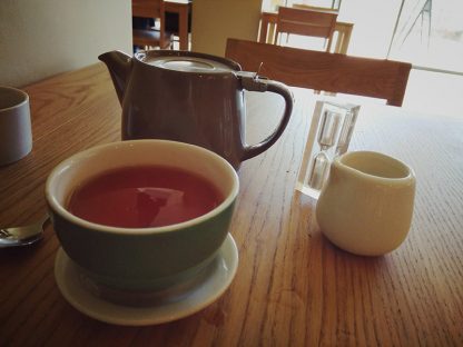 Earl Grey in a cup poured out from the pot along with a picture of the timer