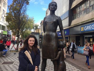 Girl in front of female statue
