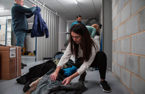 volunteers sort through donations of coats for the Wrap Up campaign