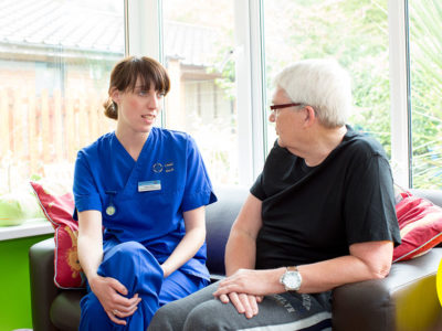 nurse talking to patient on sofa