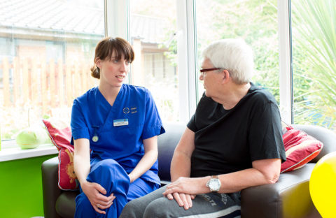 nurse talking to patient on sofa