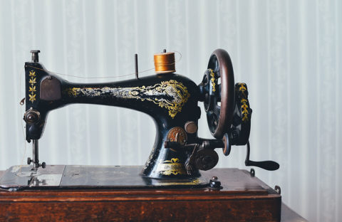 black and gold sewing machine on wooden table