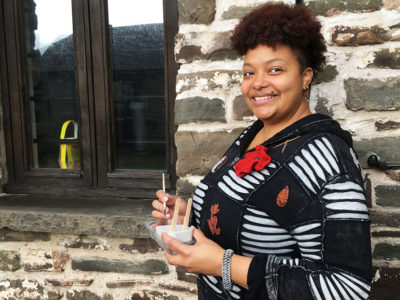 Princes Trust winner Natasha Graves stands outside her art workshop holding one of her concrete moulds for painting