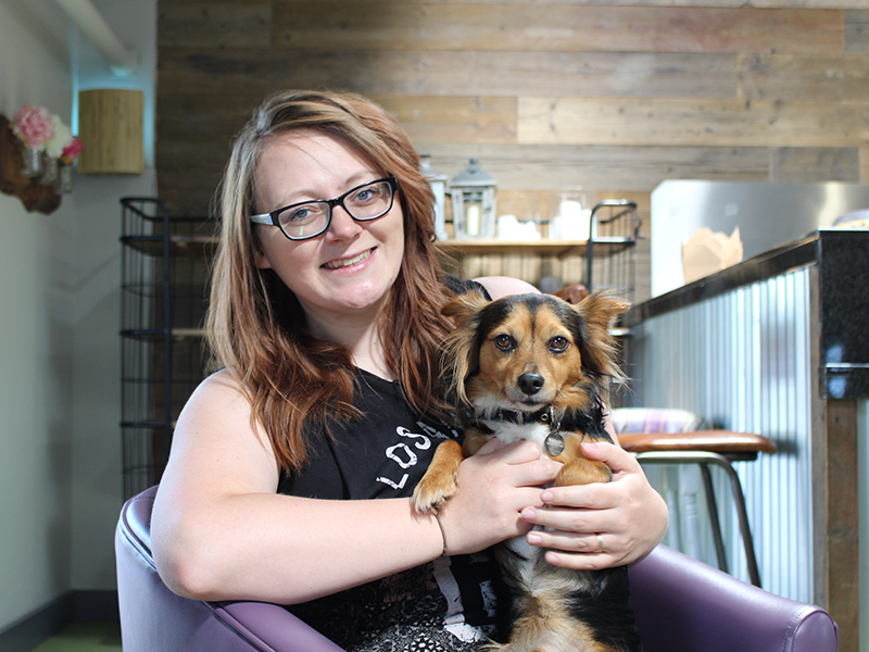 Adele from Dogfuriendly sits with her dog, Charlie on her lap