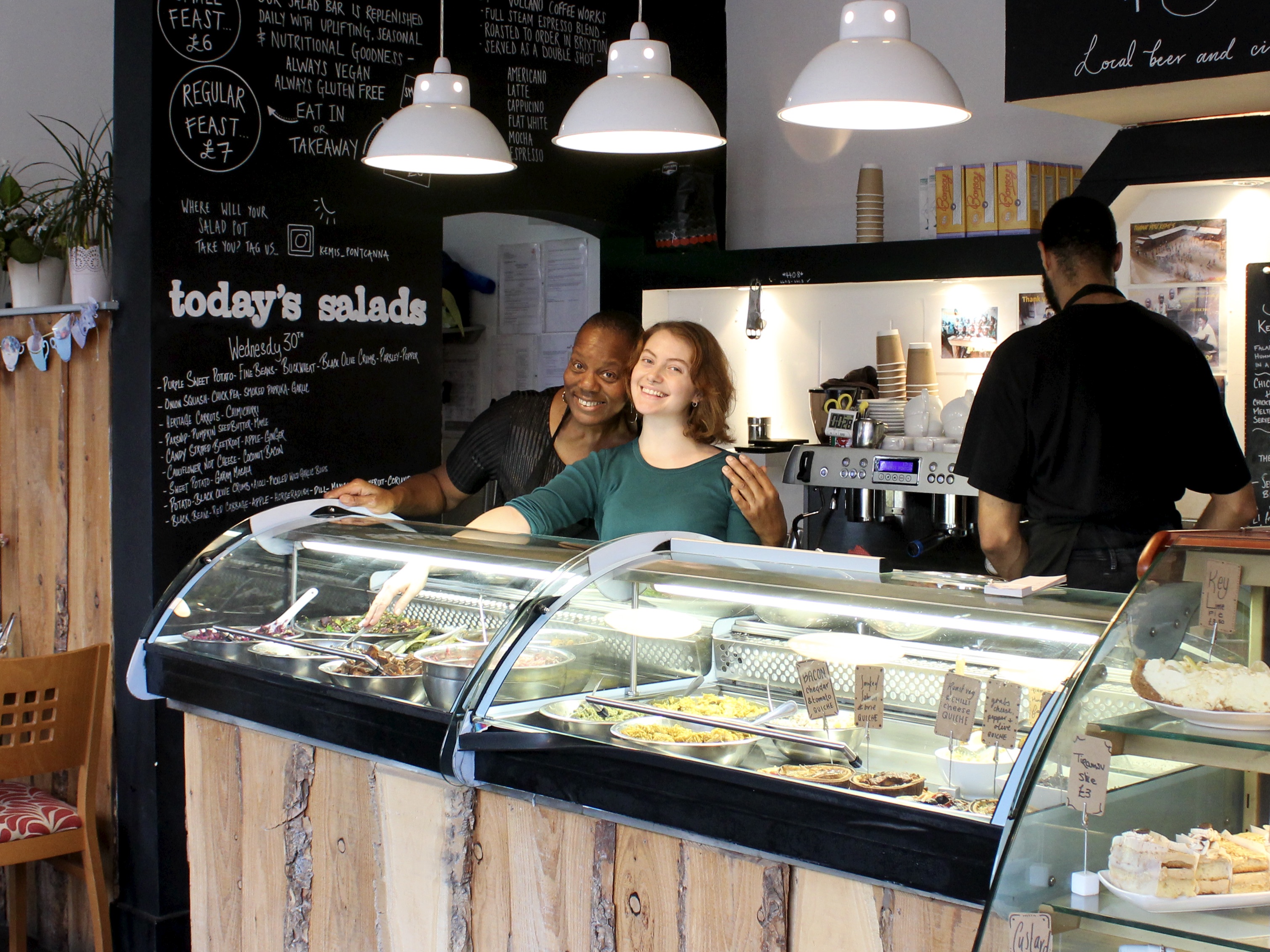 Kemi Nevins and a staff member behind the bar in Kemi's cafe