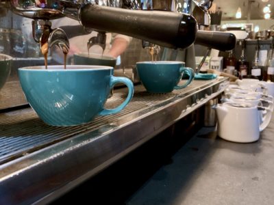 Row of blue coffee cups under espresso machine