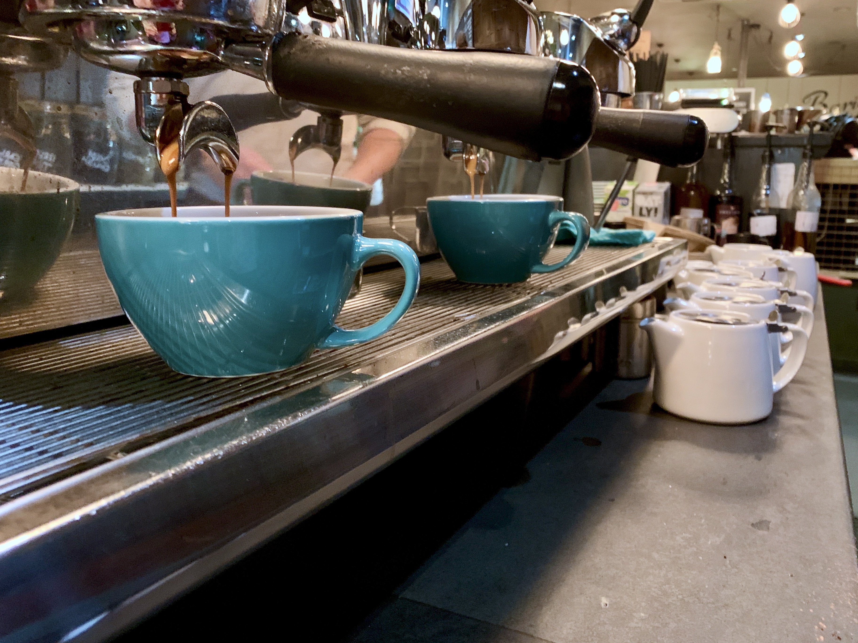Row of blue coffee cups under espresso machine