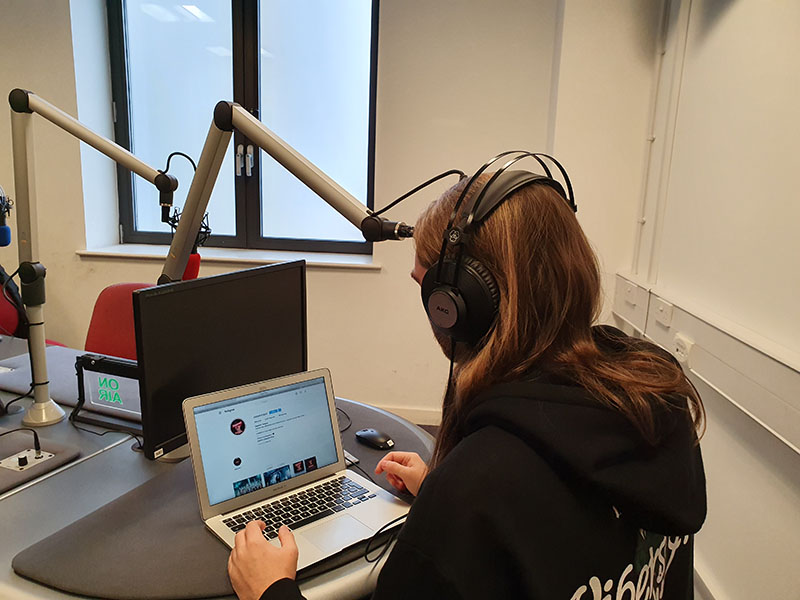 A photo of Morgan Richards recording a voice over for his music podcast titled Sappenin' Podcast, at a studio in Cardiff.