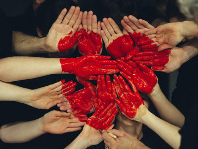 A heart painted on hands joined together.