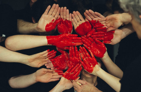 A heart painted on hands joined together.