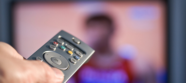 A remote control being used in front of a tv