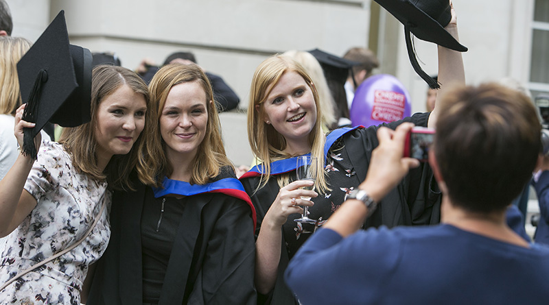 Three graduating students pose for a photo