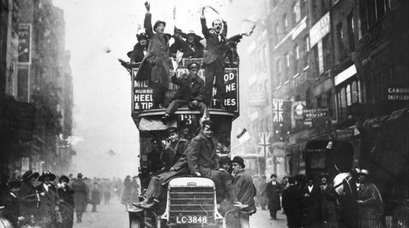 People celebrate the end of war on a London bus